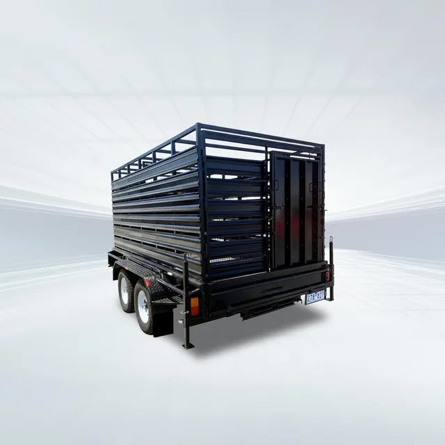 Studio rear three-quarter angled view of black stock crate trailer with mesh sides on white background.