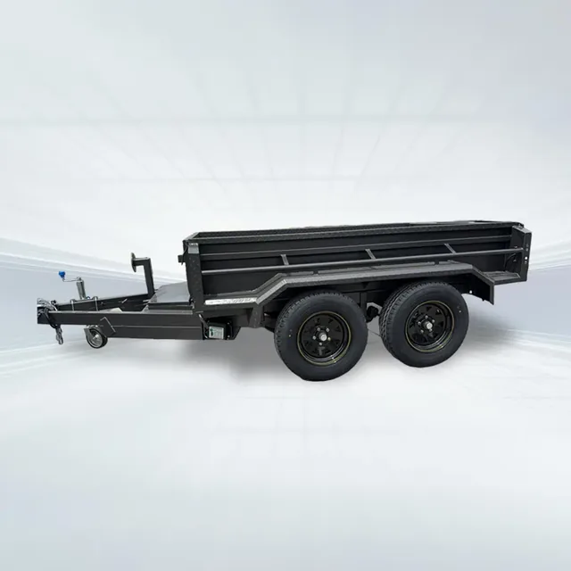 Studio side angled view of black 10x6 tandem tipper trailer with hydraulic ram and high sides on white background.