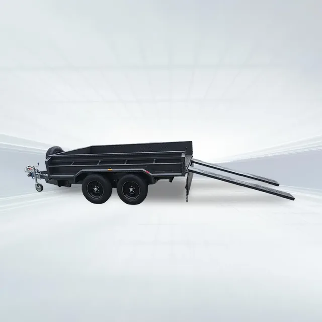 Studio side angled view of black 10x6 tandem tipper trailer with slide-in ramps and high sides on white background.
