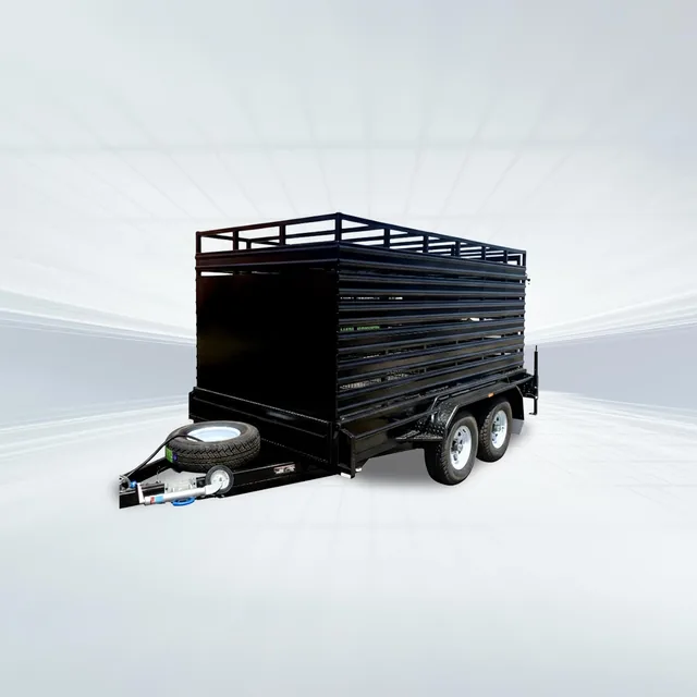 Studio side angled view of black stock crate trailer with mesh sides and spare wheel on white background.