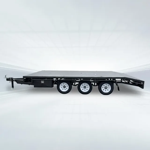 Black 5m x 2.4m flat top beavertail trailer with 4500kg GVM, tri-axle setup, perforated or checker plate deck, and lowered rear in studio setting.