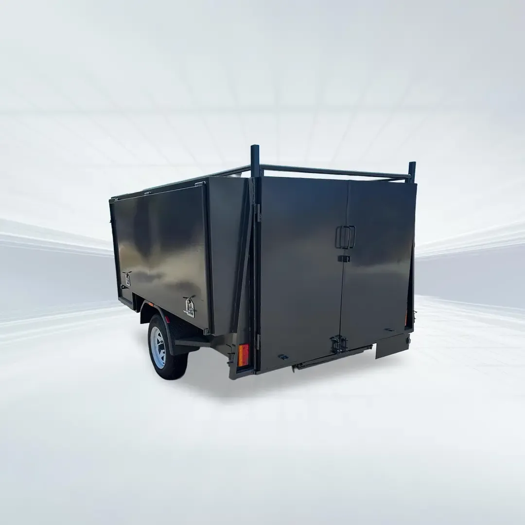 Studio rear angled view of black 7x5 lawn mowing trailer with barn doors and slide-in ramps on white background.