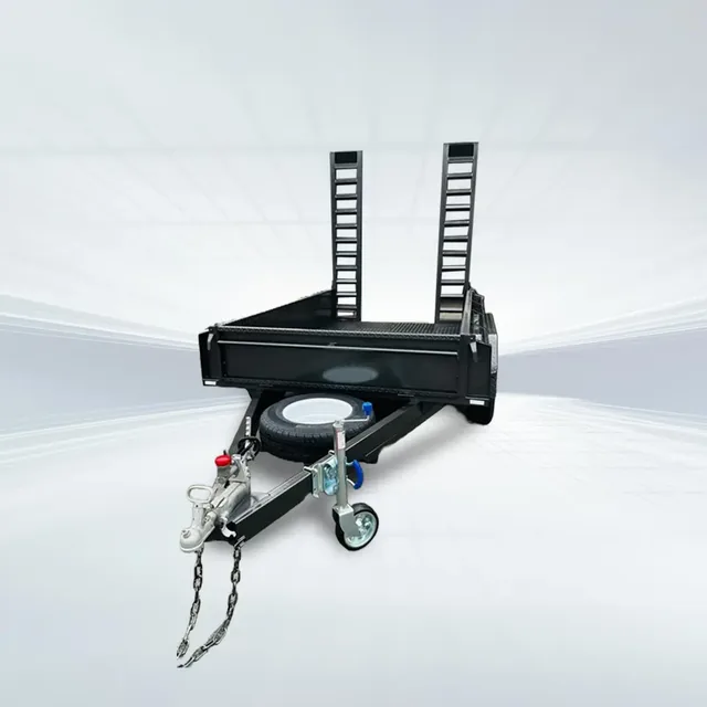 Studio rear angled view of black 8x5 machinery trailer with grip mesh deck and tall uprights on white background.